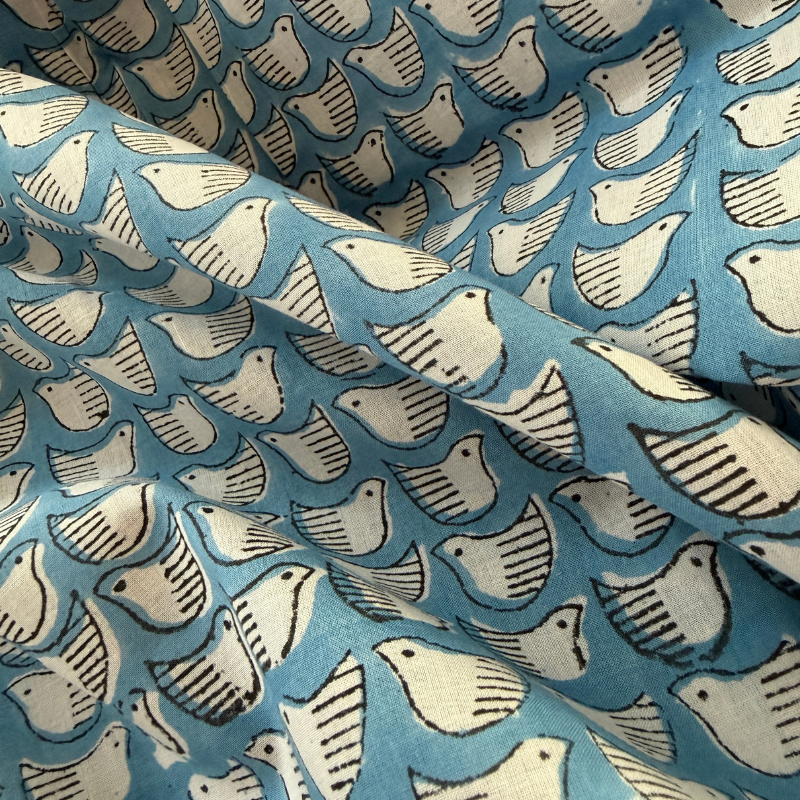 Patterned fabric with white and gray shapes on a blue background