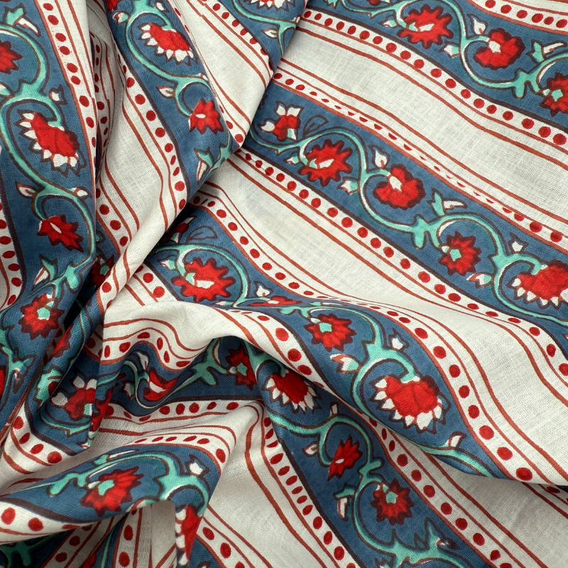 Close-up of patterned fabric with red, blue, and green design on a white background