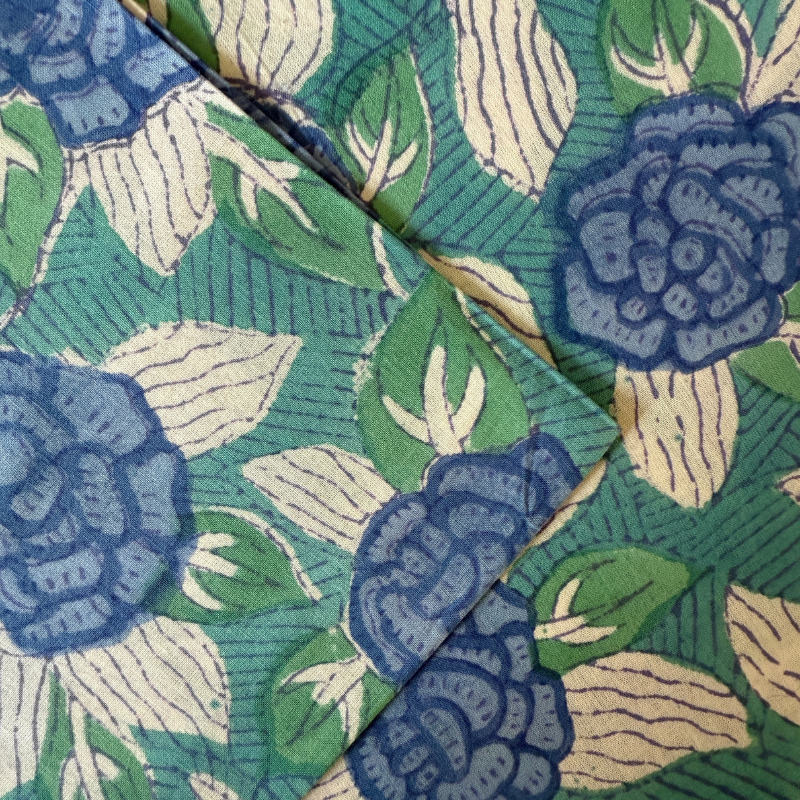 Close-up of fabric with blue floral pattern on green background