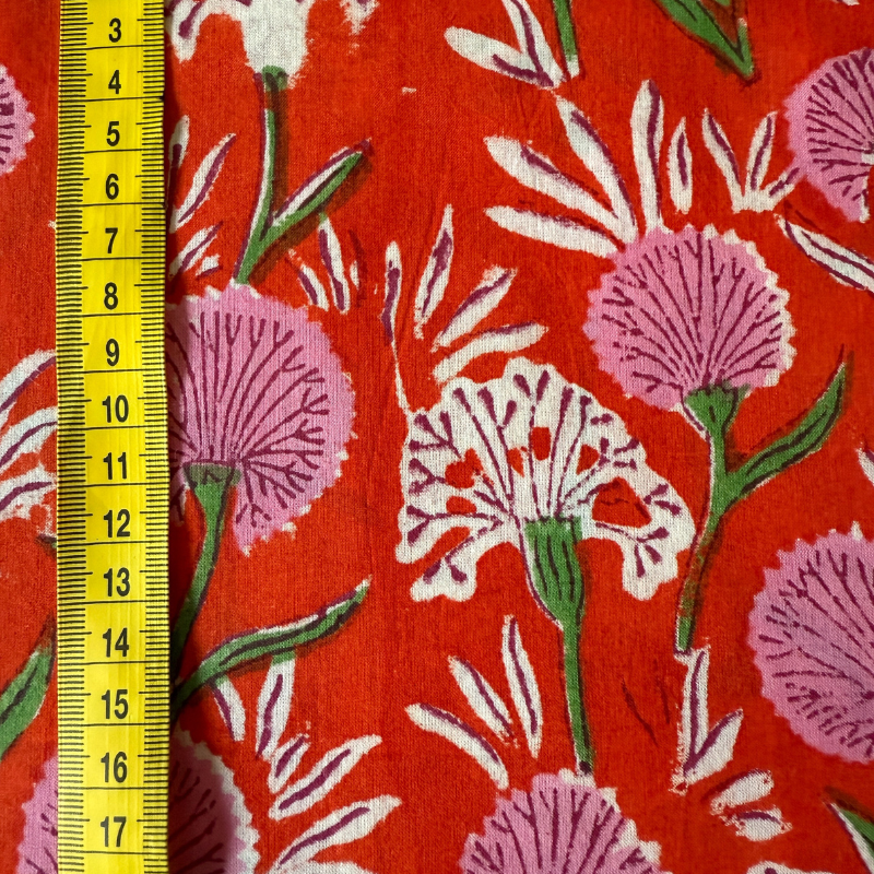 Floral patterned fabric with a measuring tape on a red background