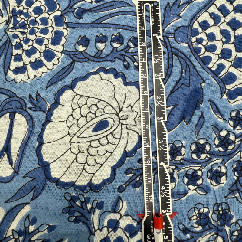 Floral patterned fabric with a ruler for scale on a blue background