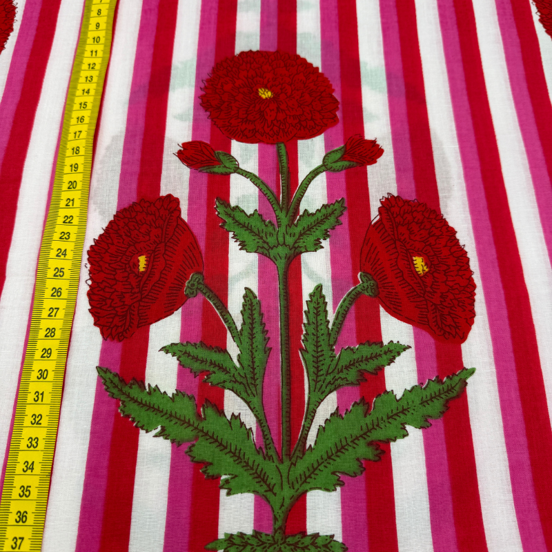 red flowers on fabric with a yellow measuring tape on a striped background