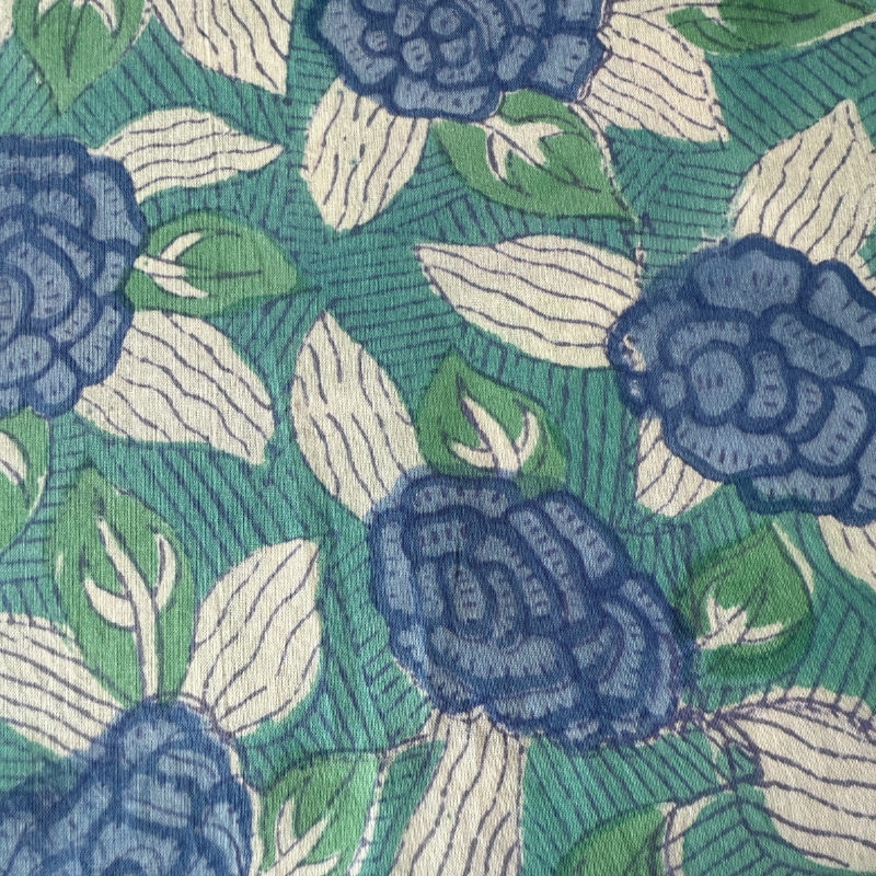 Close-up of a floral pattern with blue flowers and green leaves fabric background.