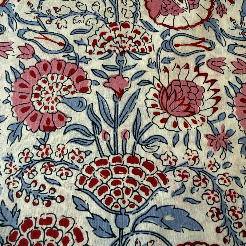Close-up of a floral pattern with red, blue, and pink colors on a beige background.