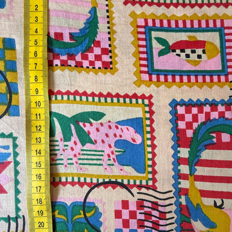 Colorful fabric with animal patterns and a ruler for scale