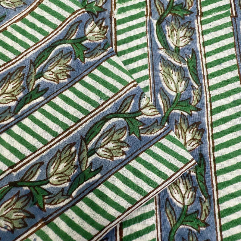 Fabric with green and white striped patterns and floral designs.