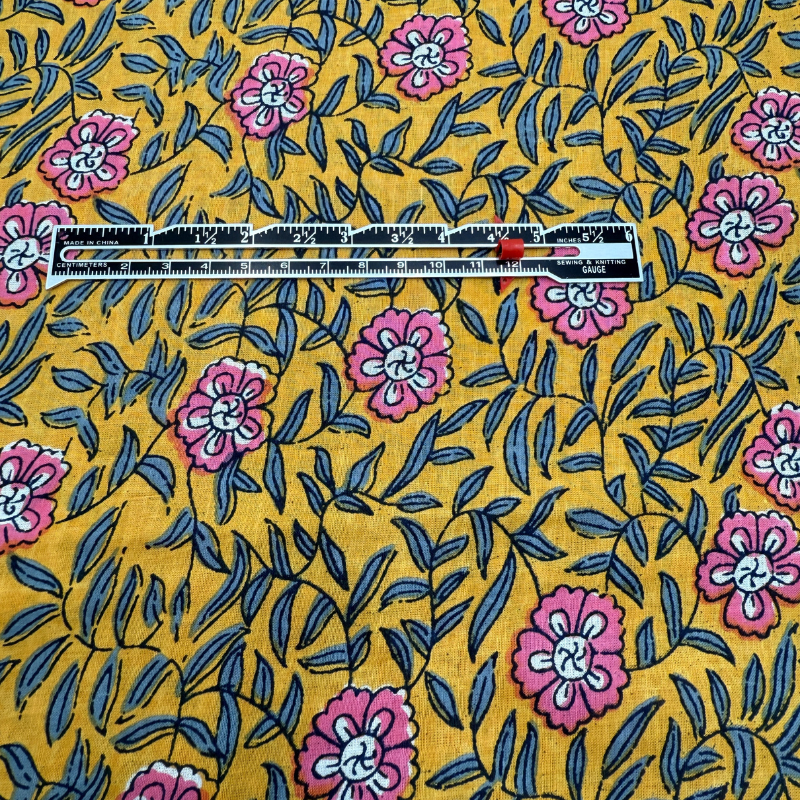 Floral fabric pattern with a ruler for scale on a yellow background