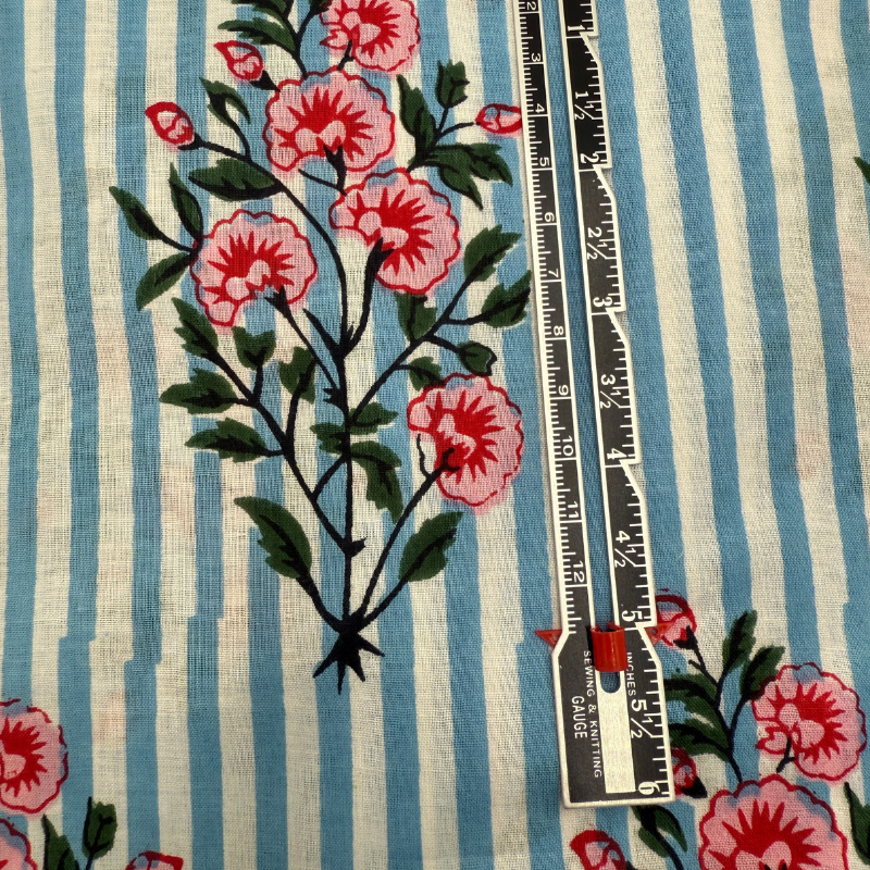 Floral patterned fabric with a ruler for scale on a striped background
