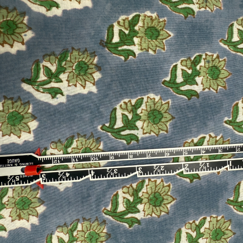 Floral patterned fabric with a ruler for scale on blue background