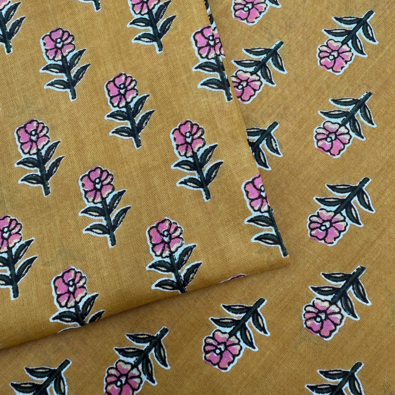 Floral patterned fabric with pink flowers and green leaves on a brown background