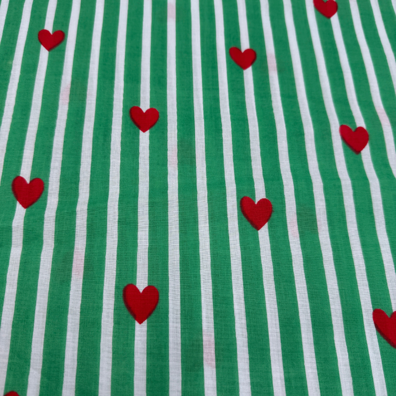 Green and white striped cotton fabric with red heart shapes