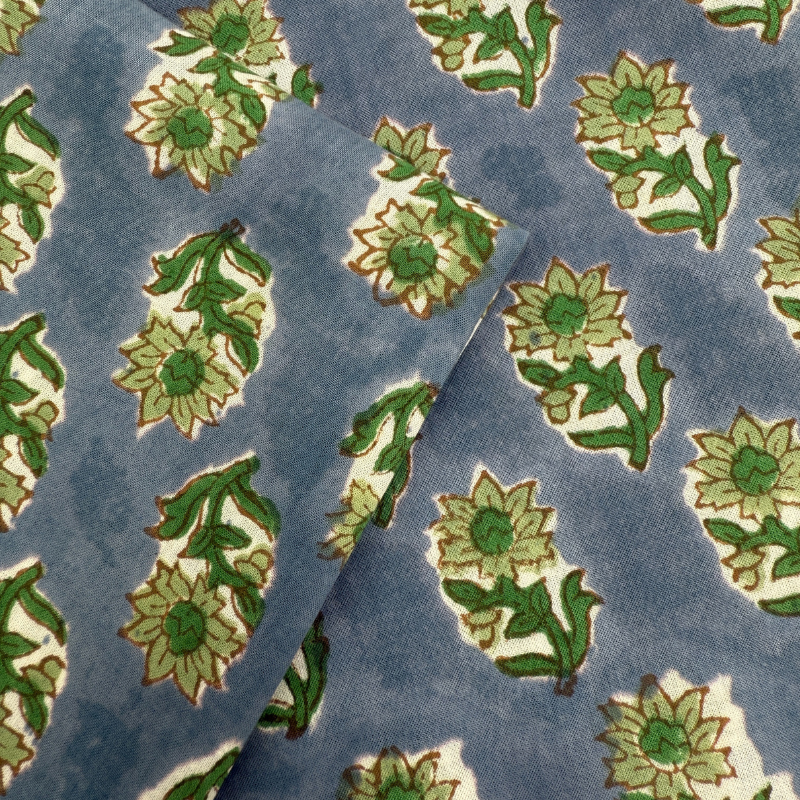 Pattern of green floral designs on a blue fabric background