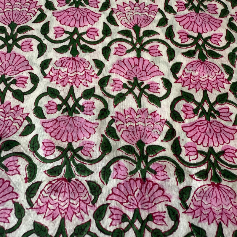 Patterned fabric with pink flowers and green leaves on a white background