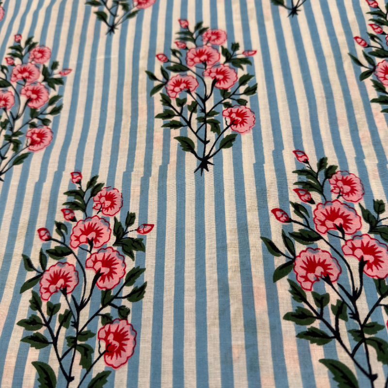 Fabric with pink floral pattern on blue and white striped background