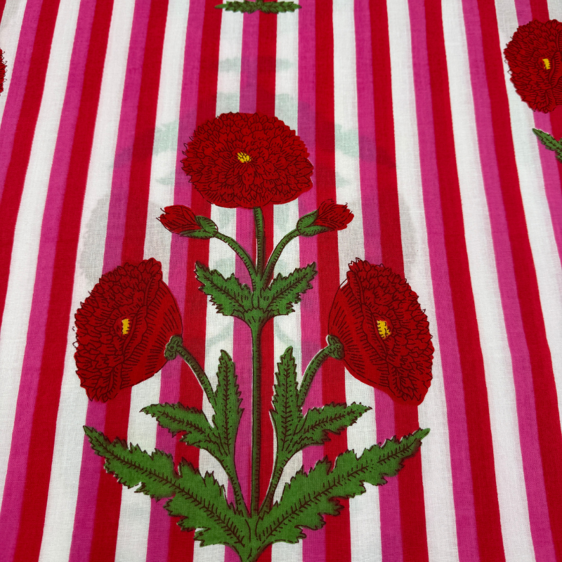 Striking red flowers on a fabric with pink and white stripes