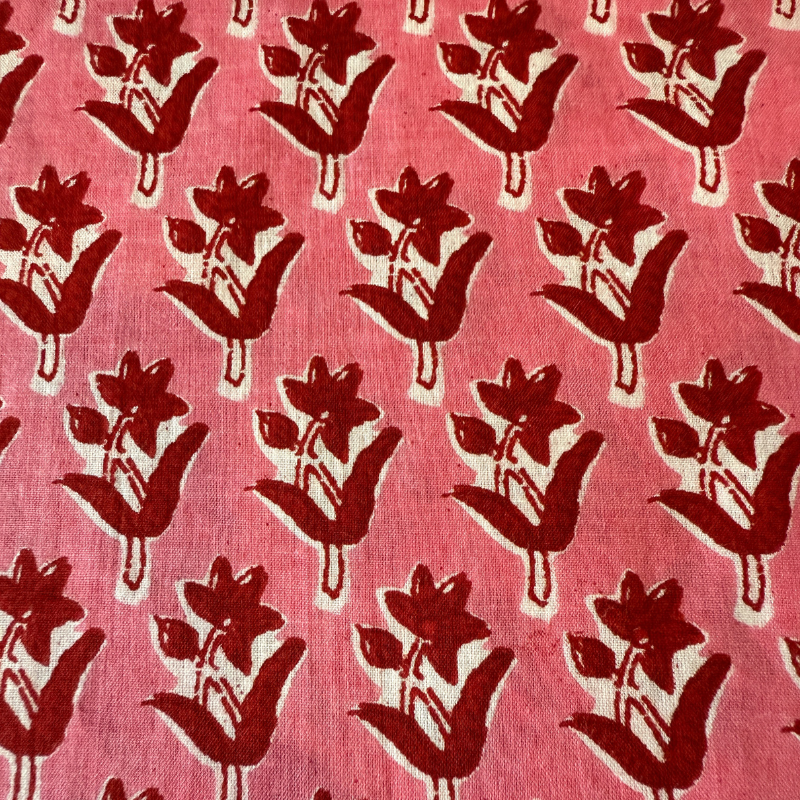 Sweet red floral pattern on a pink fabric background