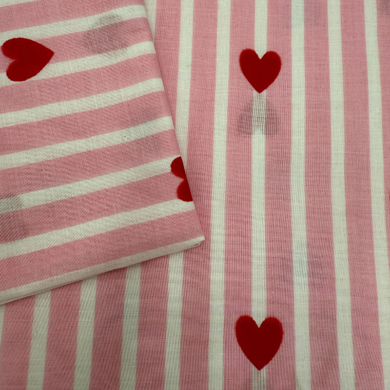 Pink and white striped fabric with red hearts